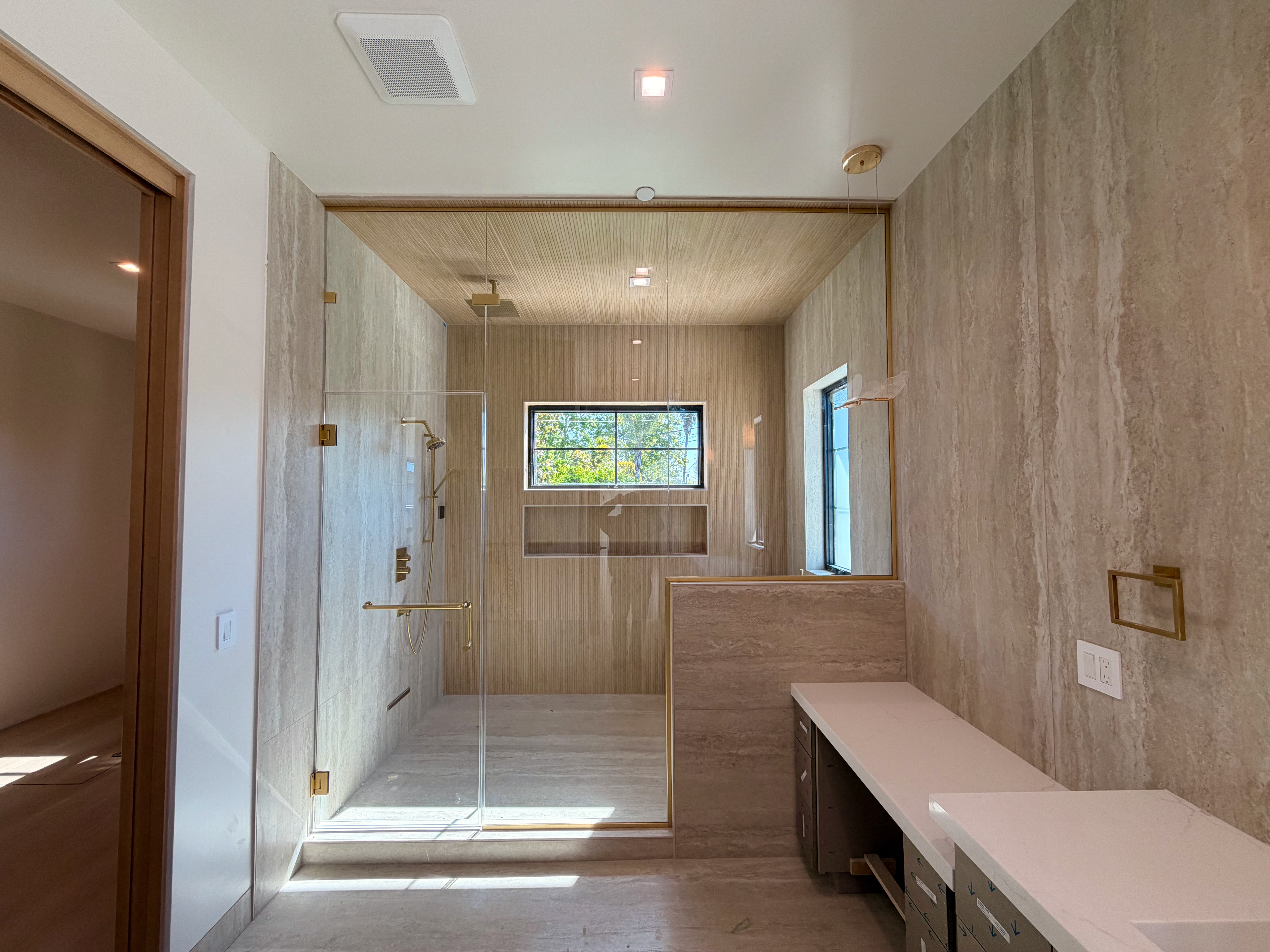 Gold-framed frameless shower enclosure
